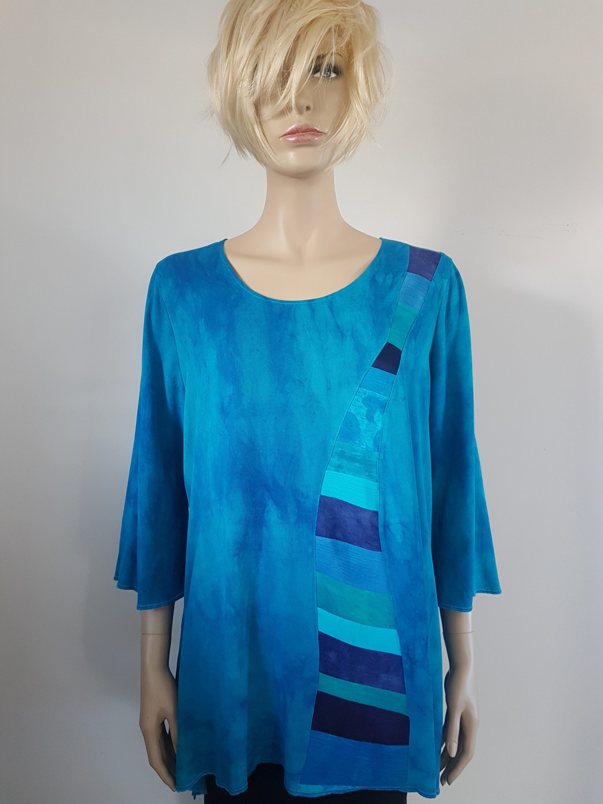Turquoise blouse met patchwork baan